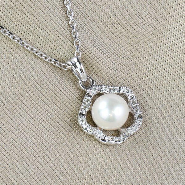 single fresh water pearl surrounded by round cut diamonds